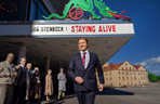 A person in a suit walking in front of a sign

AI-generated content may be incorrect.